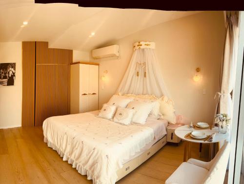 a bedroom with a white bed with a canopy at Delightful little house & Chateau Charme Suite in Auckland
