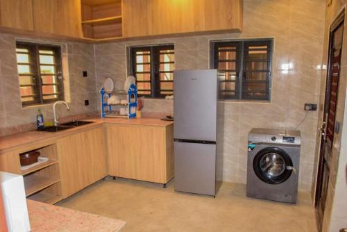 eine Küche mit einem Kühlschrank und einer Waschmaschine in der Unterkunft Gods Heritage Apartments and properties nig ltd 