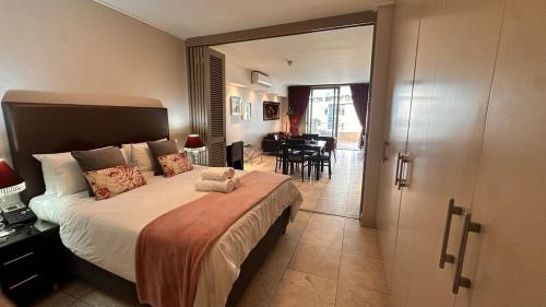 Una habitación de hotel con una cama y un comedor. en Luxury Waterfront Studio with Canal Views, en Ciudad del Cabo