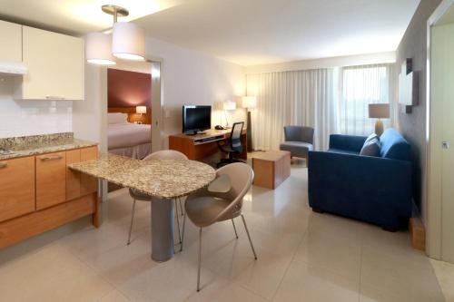 a hotel room with a kitchen and a living room at Staybridge Suites Guadalajara Expo by IHG in Guadalajara