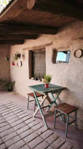 une table de pique-nique verte et un banc dans une maison dans l'établissement La Clementina, à Tilcara