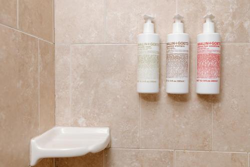 three bottles ofodorizers on a wall in a bathroom at Hotel on the Cay in Christiansted