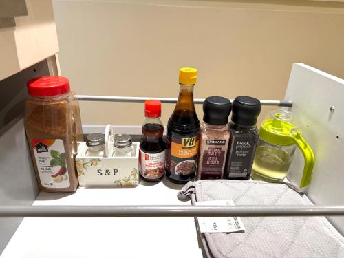 een plank in de koelkast met flesjes kruiden en specerijen bij 2BR Trafalgar Retreat near UBC & Pacific Spirit in Vancouver