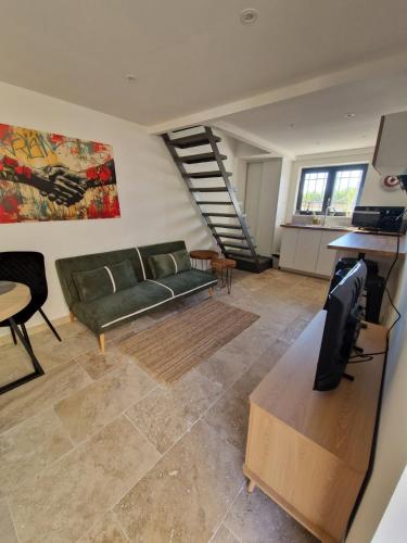 a living room with a green couch and a staircase at Duplex - Clim - Parking privé - Wifi - proche Avignon et parcs de Monteux - by CommeChezSoi in Vedène