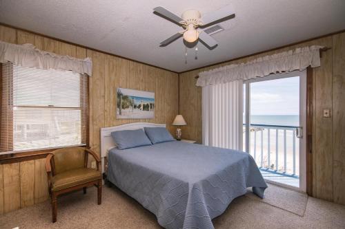 um quarto com uma cama e um ventilador de teto em Sea Breeze em Edisto Island