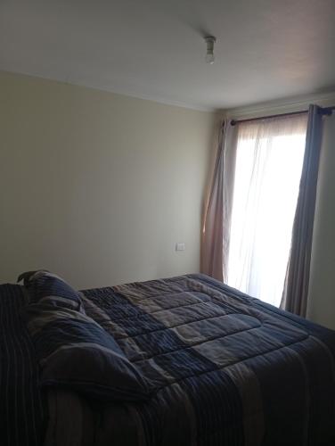 a bedroom with a bed and a window at Cabaña con vista al mar in Tomé