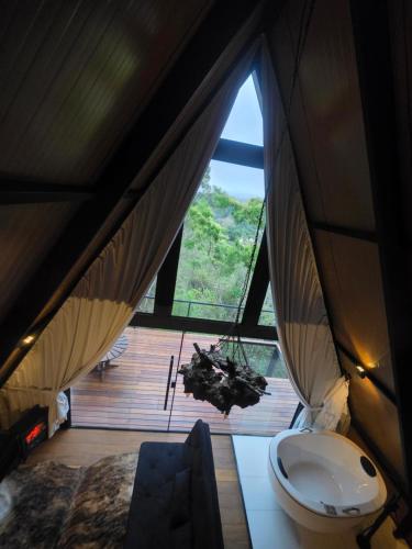 a room with a large window in a tent at Cabana Fé Miguel Pereira Com Ofuro e Por do Sol in Miguel Pereira