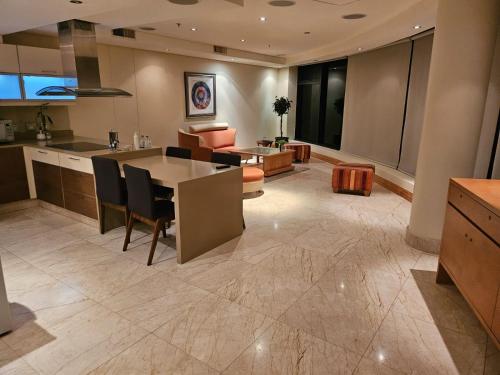 a kitchen and living room with a table and chairs at The Pearls of Umhlanga, or Oceans Apts in Durban