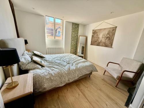 a bedroom with a bed and a chair at Perfect pied-à-terre in Dijon in Dijon