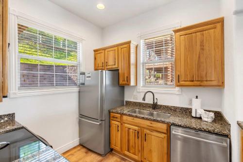 a kitchen with wooden cabinets and a stainless steel refrigerator at Always 80 and Sunny - Silver Dollar City in Branson