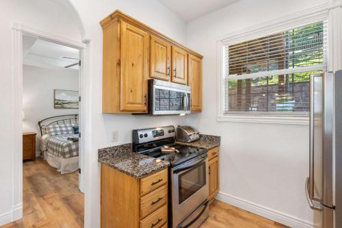 a kitchen with wooden cabinets and a stove at Always 80 and Sunny - Silver Dollar City in Branson
