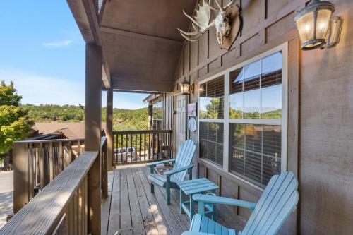 a porch with two blue chairs and a window at Grey Moose Lodge with Amenities Access in Branson West