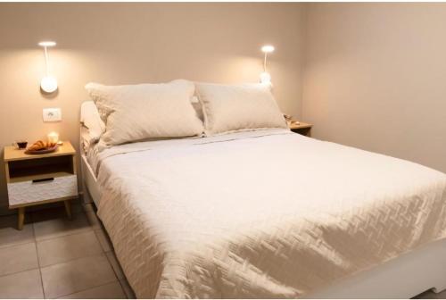 a bedroom with a large white bed with two lights at Casita Médano in El Médano