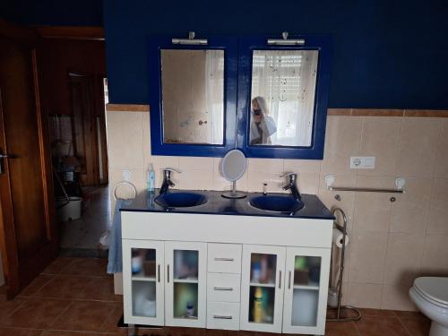 a bathroom with two sinks and a woman in a mirror at Christmas lights accommodation Vigo in Redondela