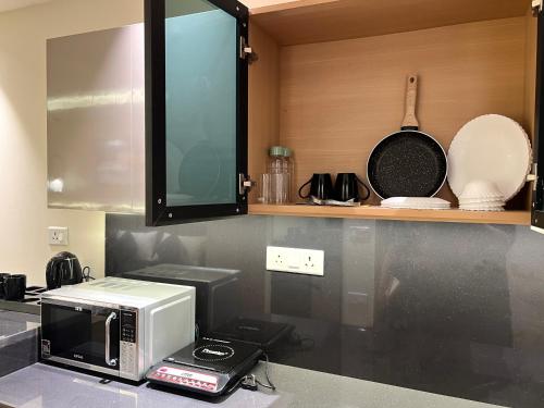 a microwave on a counter in a kitchen at Elite Stay near Expo Mart Delta 1 metro in Greater Noida