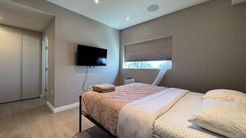 ein Schlafzimmer mit einem Bett und einem Flachbildfernseher in der Unterkunft Family apartments in hollywood in Los Angeles