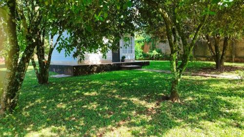 ein Park mit Bäumen und einer Bank im Gras in der Unterkunft La Comarca Tinyhouse Monoambiente in Puerto Iguazú
