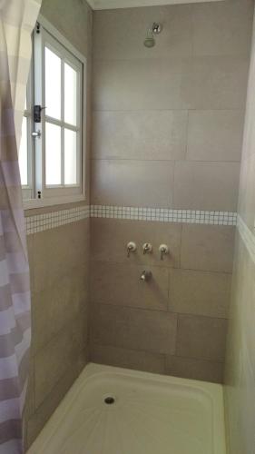 a bathroom with a bath tub with a window at La Comarca Tinyhouse Monoambiente in Puerto Iguazú