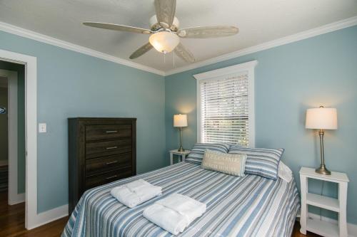 a blue bedroom with a bed with a ceiling fan at Turtle Time in Edisto Island