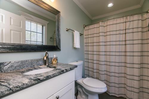 a bathroom with a sink and a toilet and a mirror at Turtle Time in Edisto Island