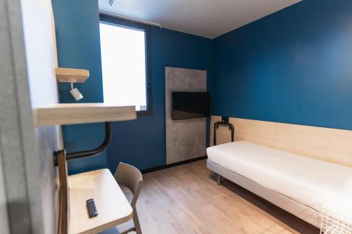 a small room with a bed and a table at ibis budget Madrid Albasanz in Madrid