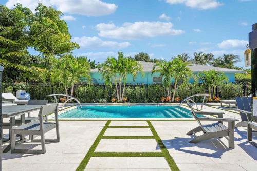 a swimming pool with two chairs and a table at Renovated Downtown Apartment - B in West Palm Beach