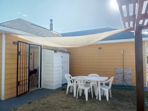 een terras met een tafel en stoelen onder een luifel bij Petrel in La Paloma