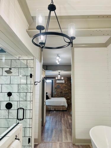 a bathroom with a large chandelier and a bedroom at Historic 706 in Mountain Home