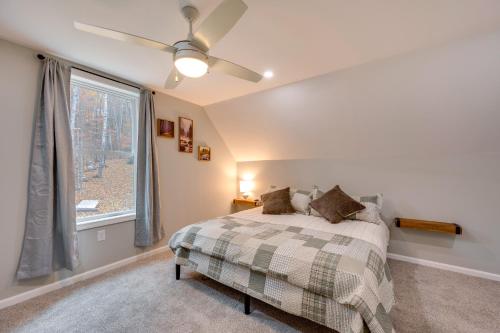 a bedroom with a bed with a ceiling fan and a window at White Mtns Holiday Home! Cabin 1 Mi to Skiing in Campton Upper Village