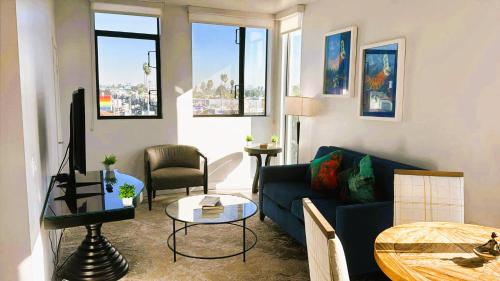 un salon avec un canapé bleu et une table dans l'établissement Melrose Luxe Retreat near The Grove, à Los Angeles