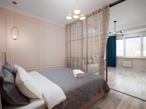 a bedroom with a large bed and a shower at Seven Elite Apartments by Mega Mall in Almaty