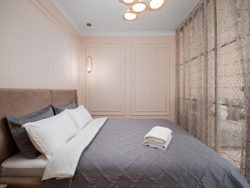 a bedroom with a bed with two towels on it at Seven Elite Apartments by Mega Mall in Almaty