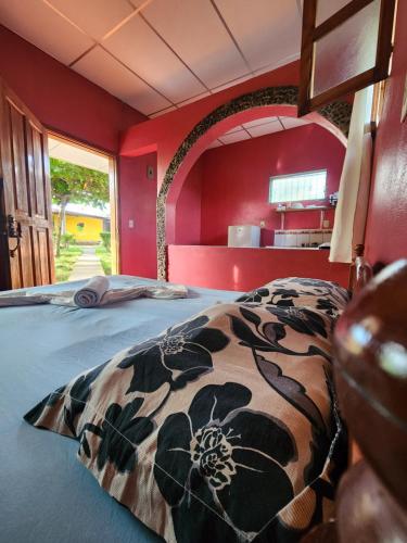a bedroom with red walls and a large bed at Hostal Bullshark in Cuatro Esquinas