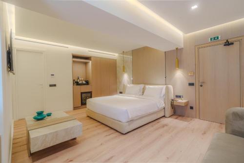 a bedroom with a large white bed and wooden floors at Eternity Athens in Athens