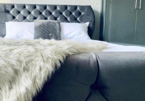 a bed with a fur blanket on top of it at Fairways guest house in Preston