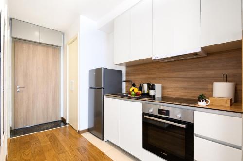 a kitchen with white cabinets and a black refrigerator at inJoy in Belgrade