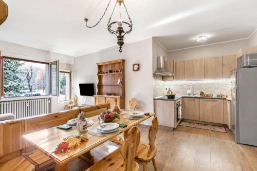 Una cocina y un comedor con una mesa de madera. en Appartamento Il Palazzo - Happy Rentals, en Bardonecchia