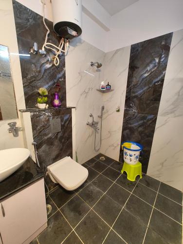 a bathroom with a toilet and a sink and a shower at Casa de Shalom - 3 Bedroom AC Villa 65" TV in Mysore