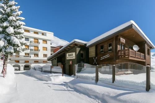 un bâtiment dans la neige devant un bâtiment dans l'établissement Hermitage Studio - close to ski pistes - Happy Rentals, à Borgata Sestriere