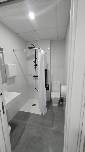 a white bathroom with a shower and a toilet at ALMA one in Alicante