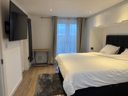 ein Schlafzimmer mit einem großen Bett und einem großen Fenster in der Unterkunft Comfy En-suite King Size room in Hornchurch