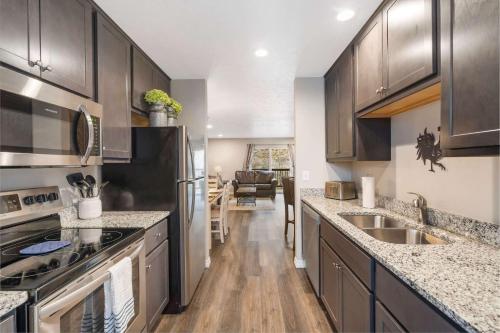 a kitchen with stainless steel appliances and wooden cabinets at Rockwall Duo - Cottage & Lodge Combo in Branson