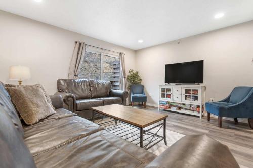 a living room with a couch and a tv at Rockwall Duo - Cottage & Lodge Combo in Branson