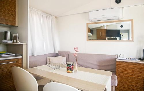 a living room with a table and a couch at Pet Friendly Stacaravan In Drnis With Wifi in Brištane