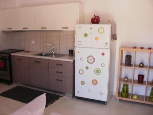 a kitchen with a white refrigerator and a sink at Afroessa Studios & Apartments in Samos