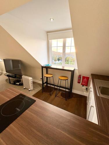 a small kitchen with a table and two stools at The Whitehouse in Pontypridd