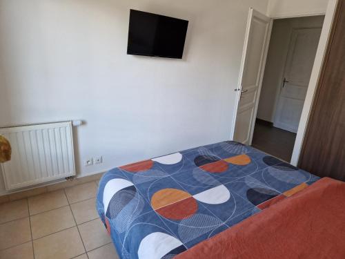 a bedroom with a bed and a tv on the wall at Chambre accueillante in Prévessin