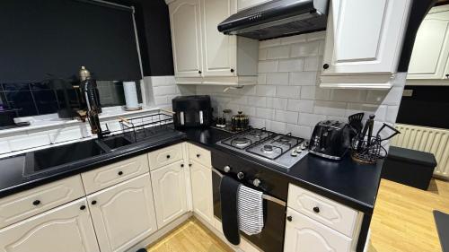 a kitchen with white cabinets and a stove top oven at A Star Living in Liversedge