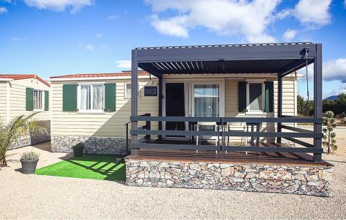 a house with a porch with a black awning at 3 Bedroom Nice Stacaravan In Drnis in Brištane