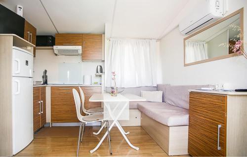 a kitchen and a living room with a table and a couch at 3 Bedroom Nice Stacaravan In Drnis in Brištane